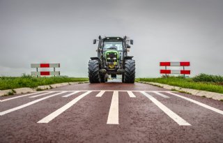 Friese boeren stuiteren in trekker over drempels op weg