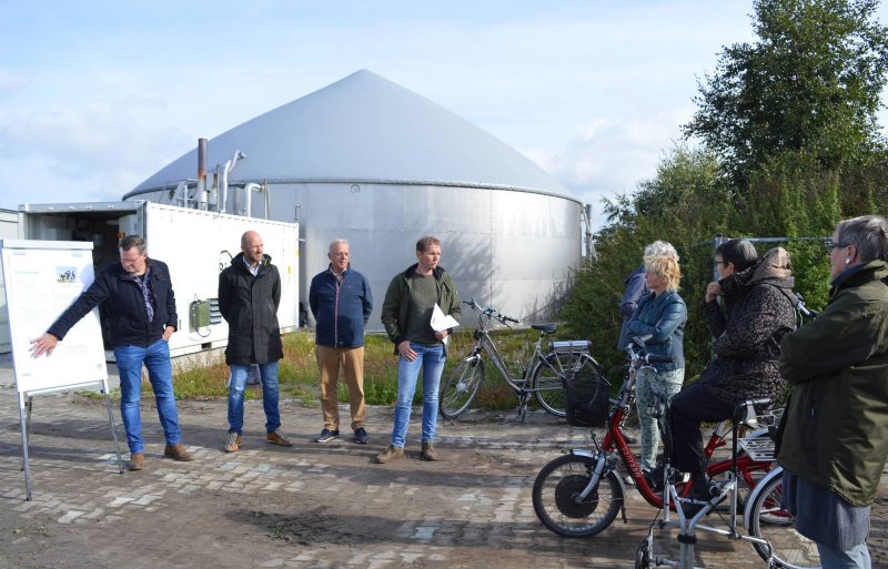 Jetta Klijnsma, midden op fiets, krijgt bij de biovergister van Tijmens in Koekange een presentatie over de Energiecoöperatie Koekange-Echten