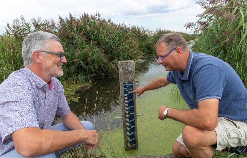 Projectleider Bart Budding (links) en akkerbouwer Douwe Monsma beoordelen het waterpeil.