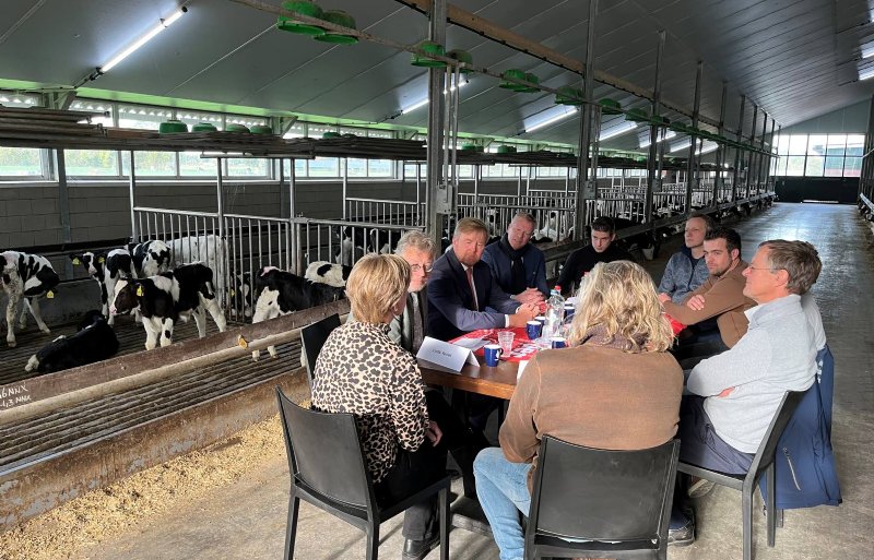 Koning Willem-Alexander in gesprek met vertegenwoordigers van boerenorganisaties tijdens een werkbezoek aan een veehouderij in Terschuur.