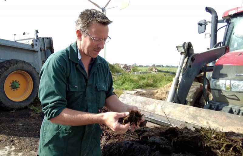 Melkveehouder Mennard Hofman uit Noordhorn beoordeelt de gecomposteerde mest.