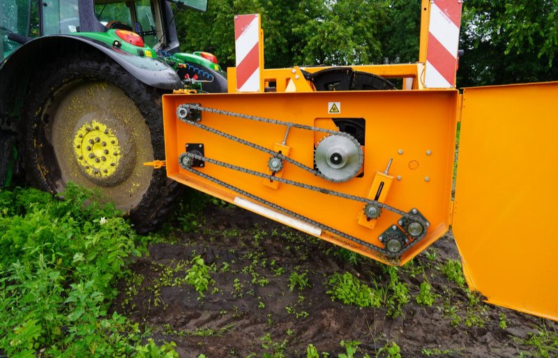 De aandrijving verloopt mechanisch via een kettingkast aan de zijkant van de machine.