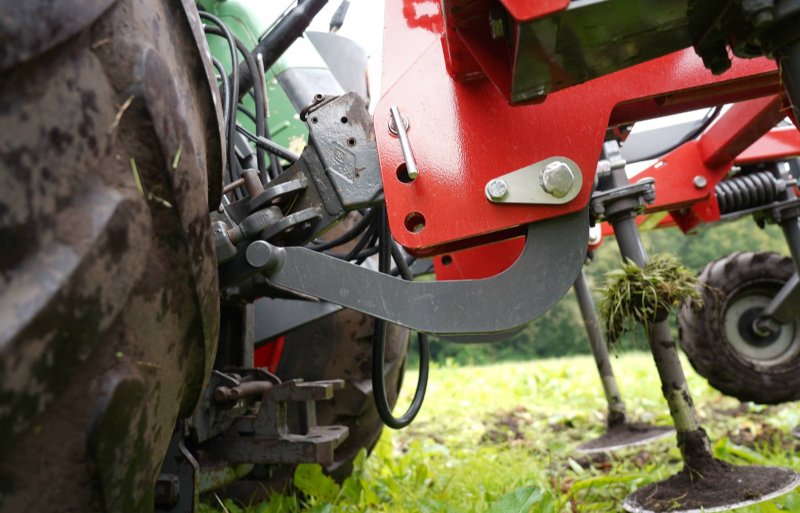 Een cilinder en een beugel onder de heflatten drukken de machine de grond in.