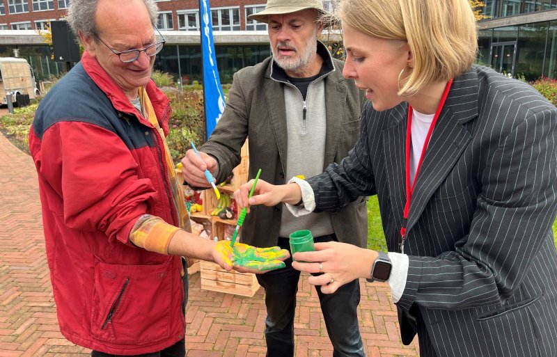 Bioboeren Digni van den Dries en Jaap Korteweg en duurzaamheidsspecialist Imre ter Hedde van Lidl treffen voorbereidingen voor een handafdruk.