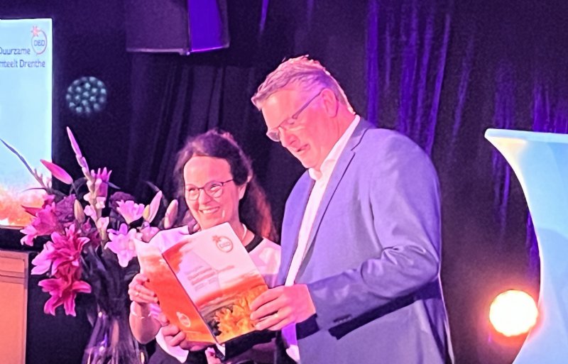 Susanne Sütterlin van LVVN en gedeputeerde Gert-Jan Schuinder krijgen het rapport van het programma Duurzame Bollenteelt Drenthe overhandigd.