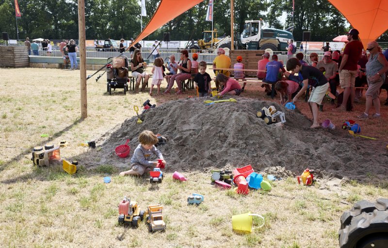 De kleinsten vermaken zich onder een groot schaduwdoek.