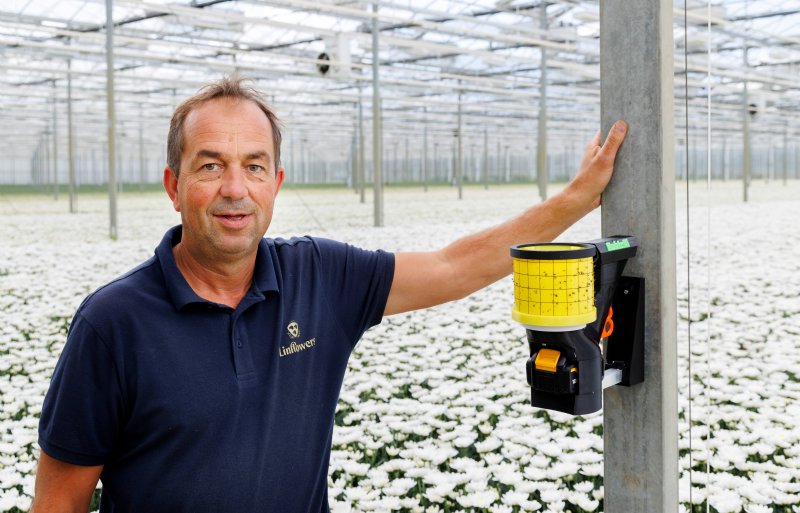 Chrysantenkweker David van Tuijl van Linflowers naast een van de vijftien Robcams.