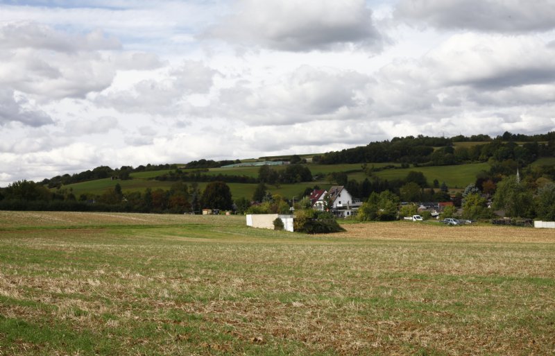 Een braakliggend perceel met op de achtergrond het dorpje Bengen.