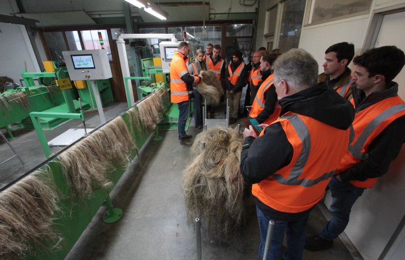 Bart Depourcq (links) geeft bij Van de Bilt zaden en vlas uitleg over het verwerkingsproces van hennep tot lange vezels die bestemd zijn voor de textielindustrie.