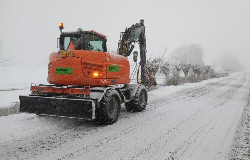 Loonwerker Jos Kromwijk in het Utrechtse Woerden ploetert voort, terwijl de sneeuw stevig valt.