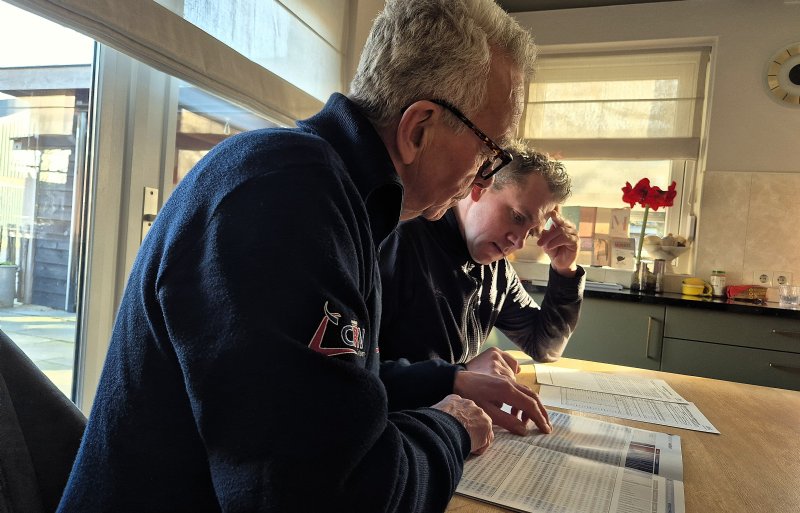 Stamboekinspecteur Leo Teunis aan tafel met rundveehouder Matthijs Pots over stierkeuze.