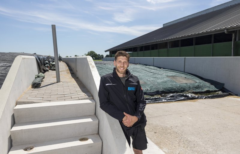 Jasper Oskam bij de trap tussen de twee sleufsilo’s. ‘Met het afdekken van de kuil hoeven we er nu niet bovenop te klimmen.'