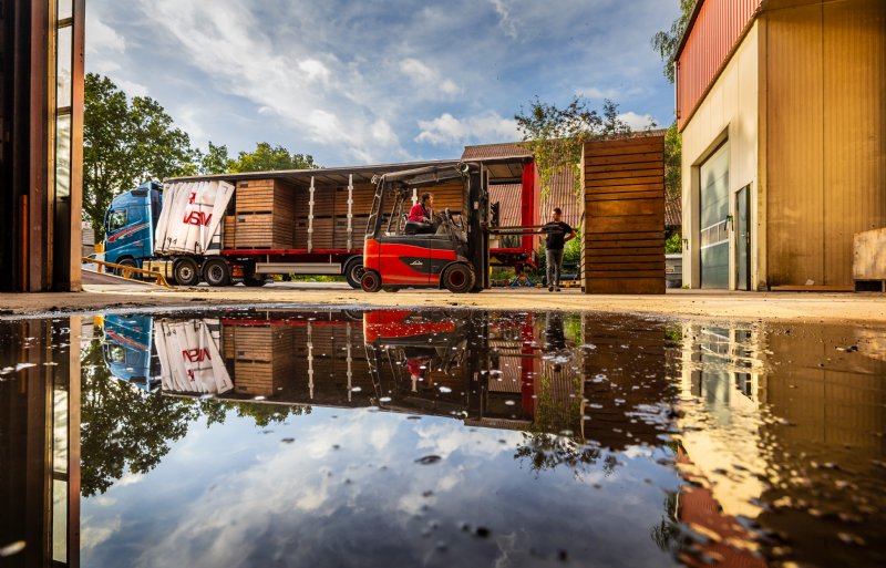 Kisten met pootgoed gaan vanuit de aanhanger naar de bewaring, lege kisten worden weer op de wagen geladen.